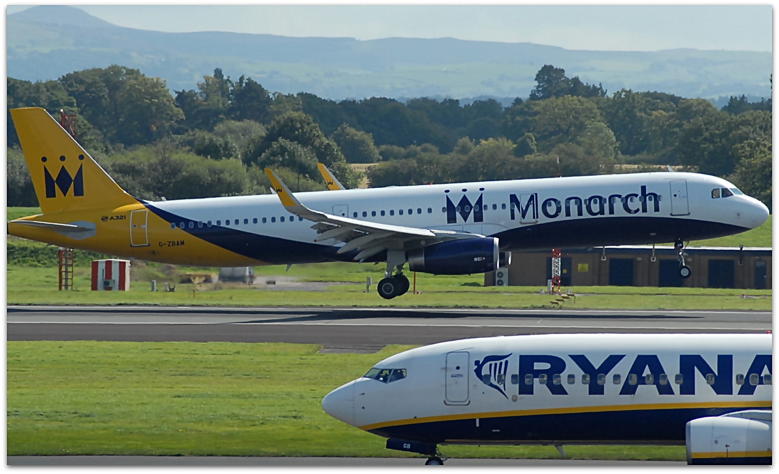A Monarch airways plane in the background with a Ryanair plane in the foreground, at Manceshter Airport.